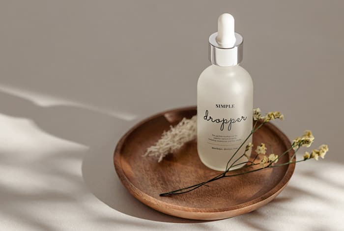 Frosted dropper bottle on wooden tray mockup